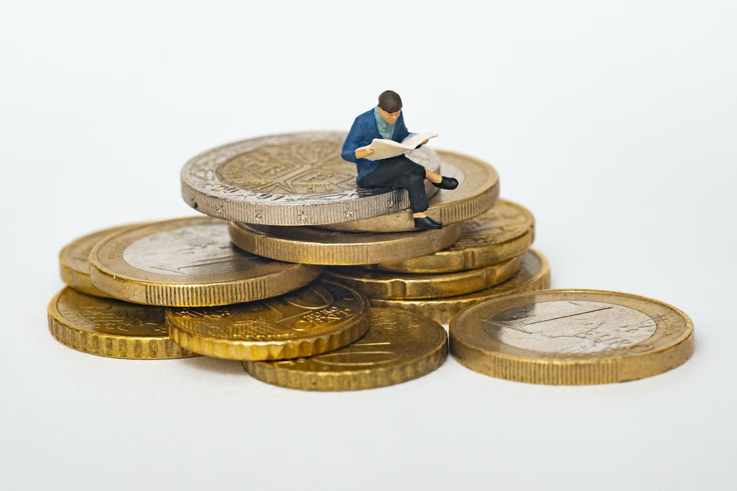 a man sitting on coins indicating a successful investment