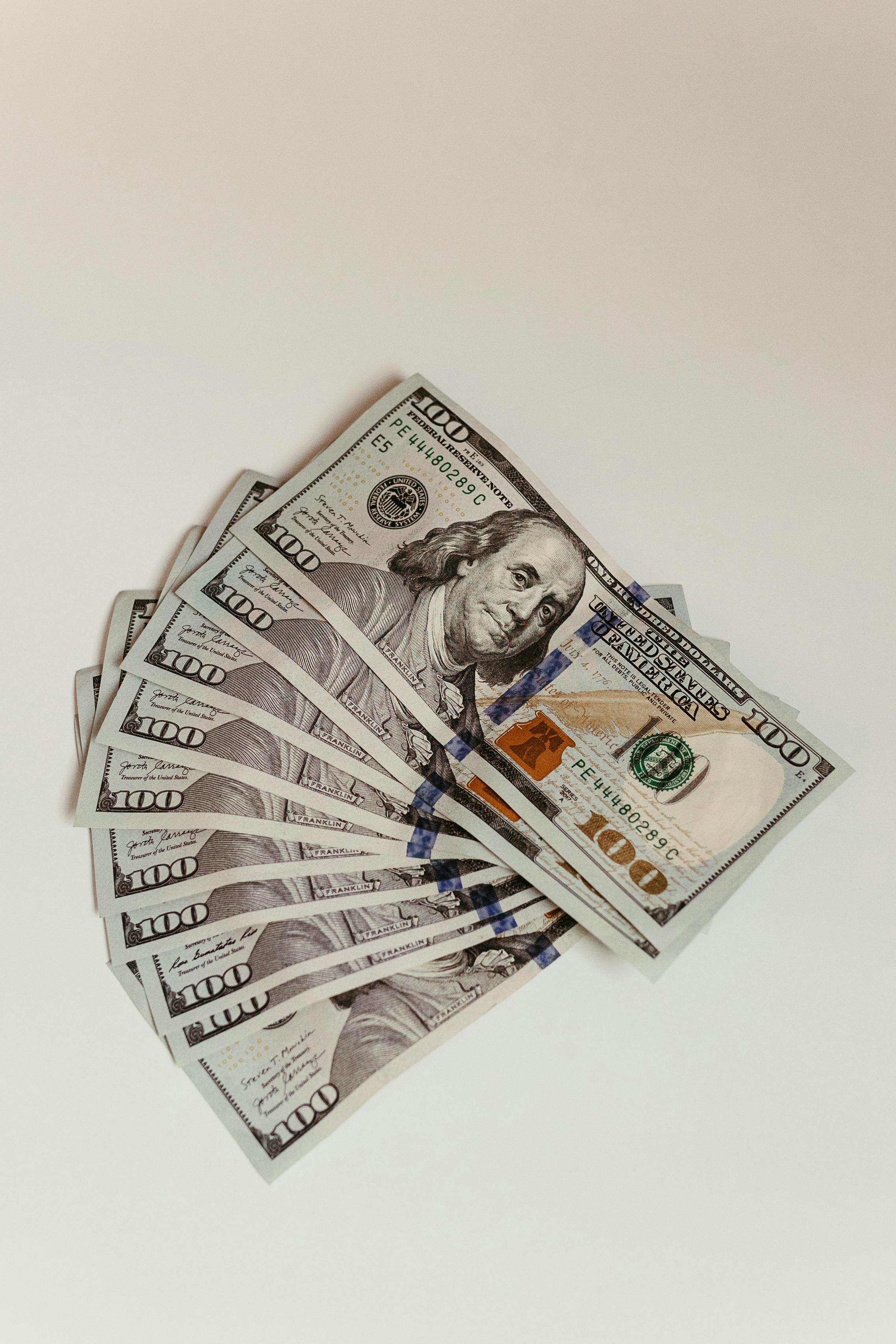 100 US dollar banknotes on a white surface
