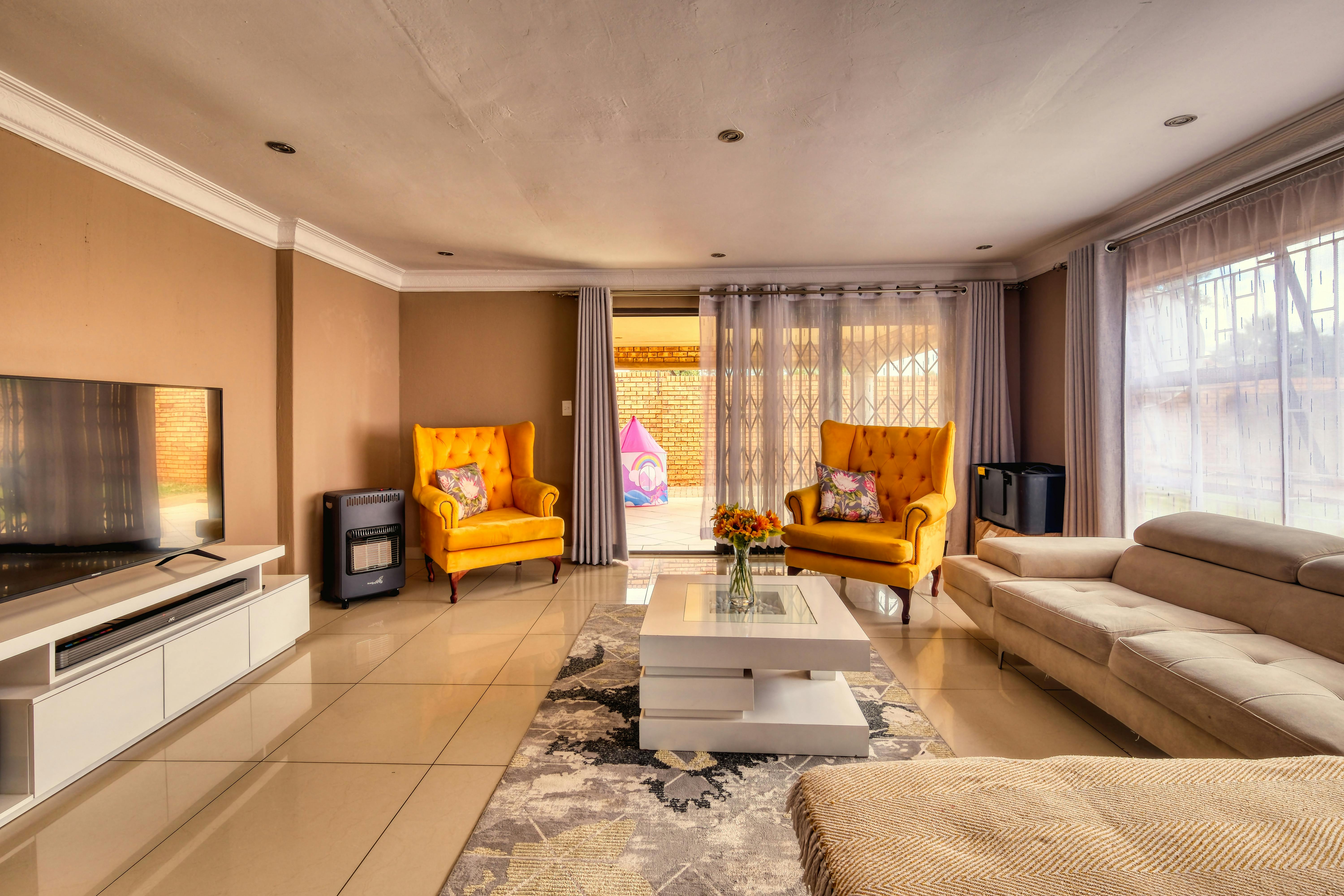 A modern cozy living room with white marble floor and yellow sofa set