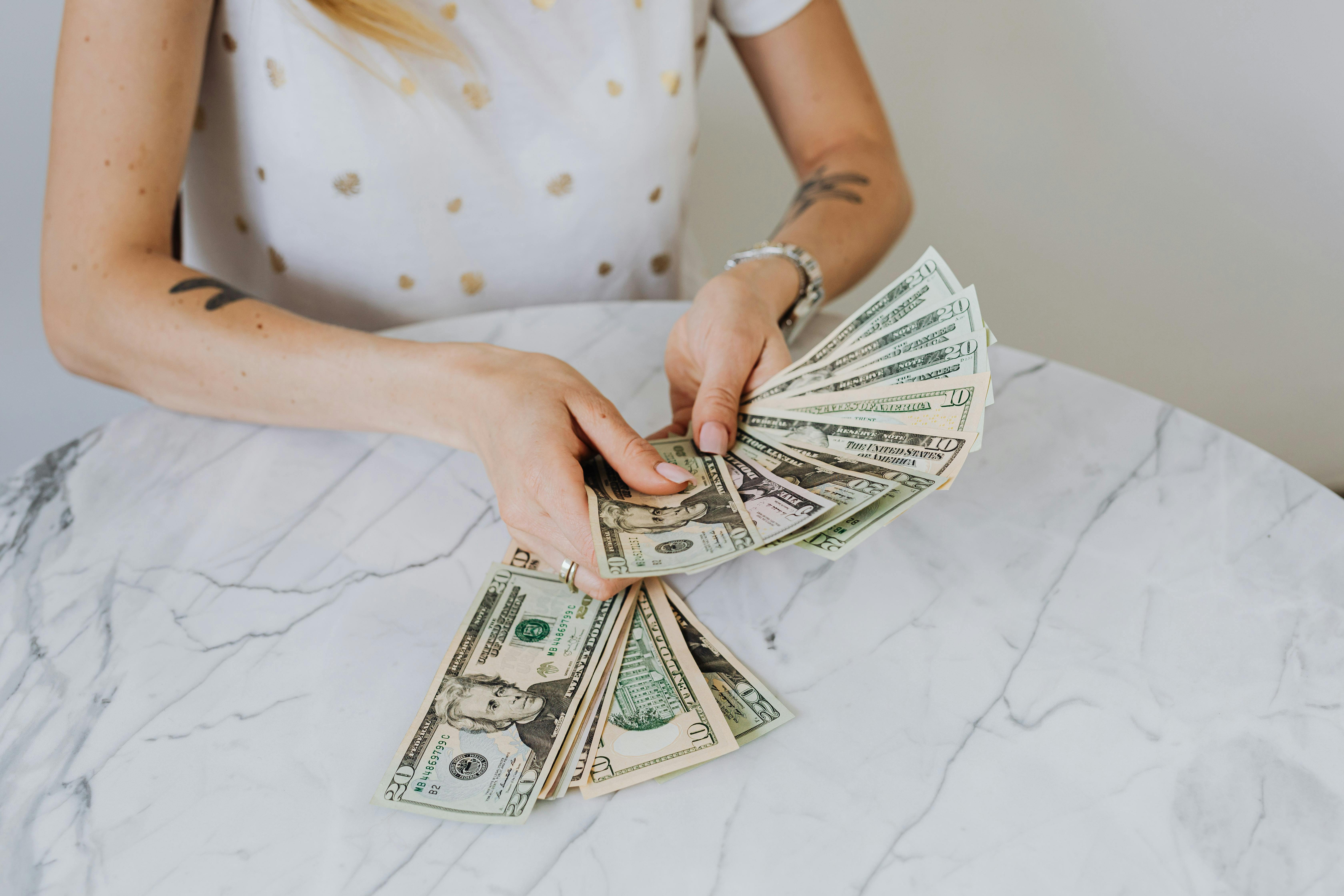 A person counting US dollars