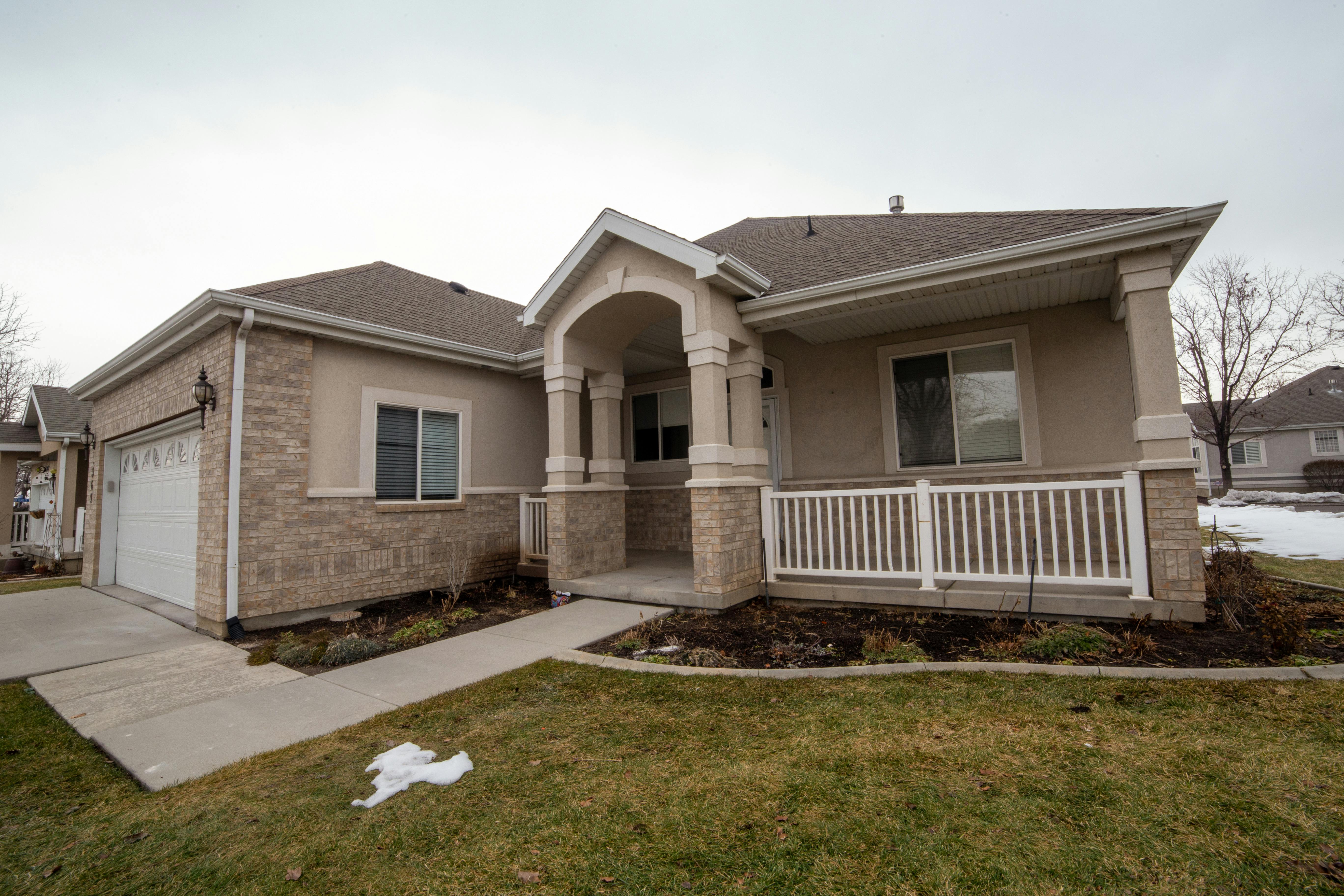 A brown concrete house with a lawn