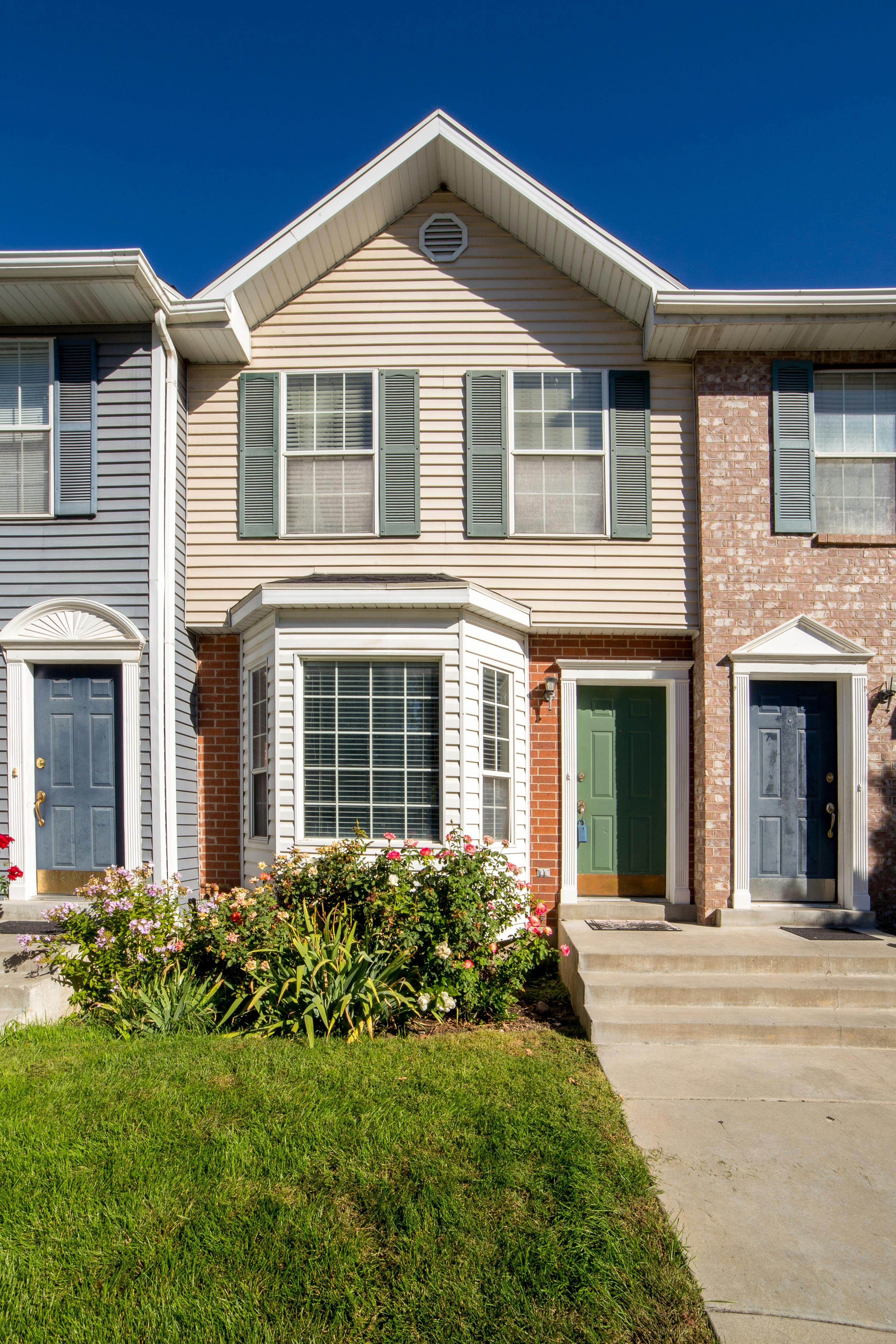 A house with a lawn grass and concrete driveway in front