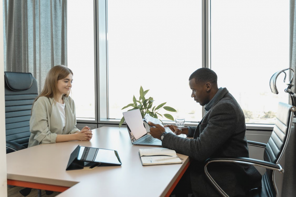 A real estate agent discussing property details with a client in an office.