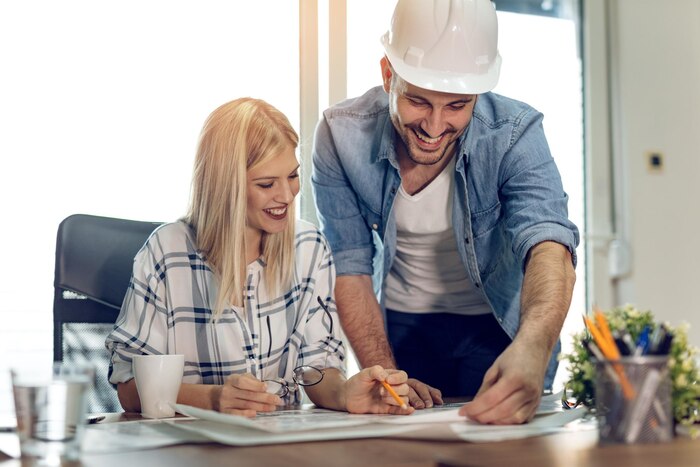 young-successful-architect-colleagues-talking-analyzing-blueprints-while-working-new-project-office_360066-2409